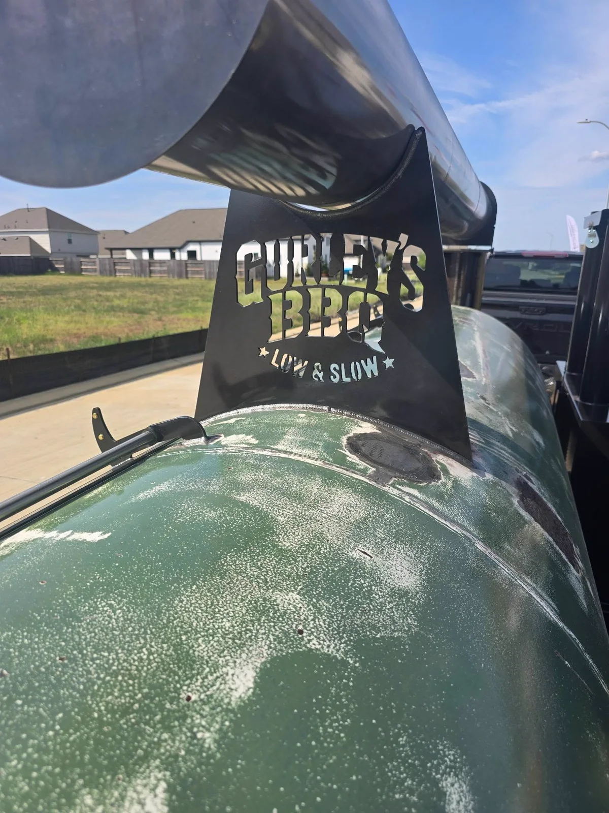 Gurley’s distinctive green smoker with its branded Low & Slow metal sign